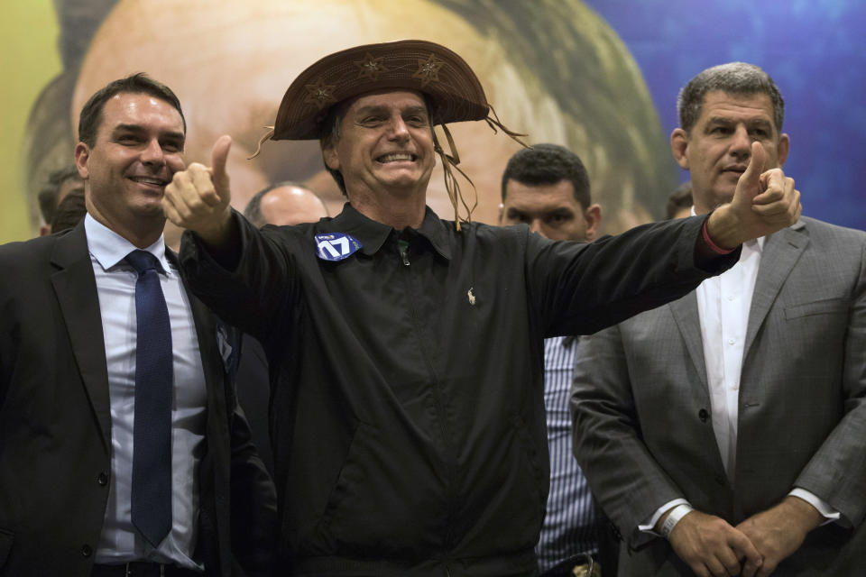 FILE - In this Oct. 11, 2018 file photo, presidential candidate Jair Bolsonaro flashes two thumbs up during a press conference in Rio de Janeiro, Brazil. The success of Bolsonaro's campaign caught many by surprise as the far-right congressman tapped into an anti-establishment wave. He focused on cracking down on crime and wooing the business community with a promise to enact liberal economic policies. (AP Photo/Leo Correa)