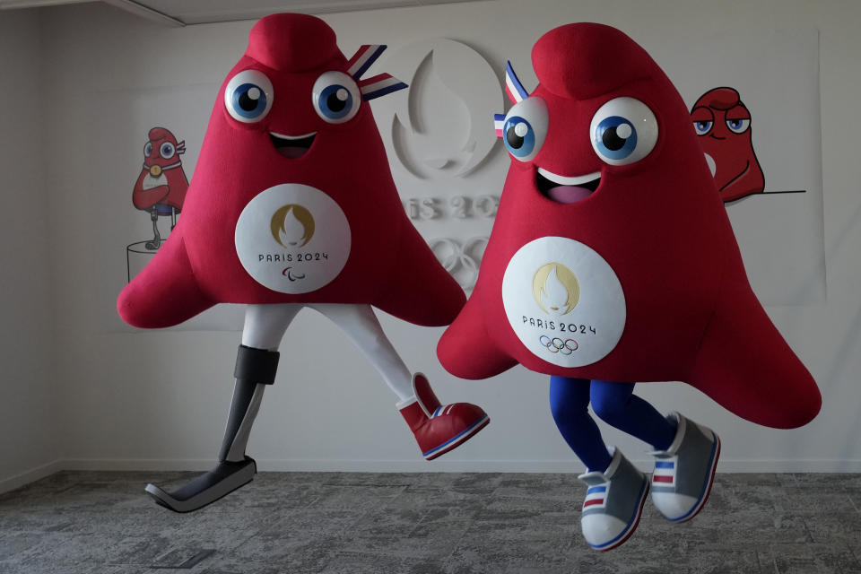 Mascots of the 2024 Paris Olympic Games, right, and Paralympics Games, a Phrygian cap, jump during a preview in Saint Denis, outside Paris, Thursday, Nov. 10, 2022. The soft bright red cap, also known as a liberty cap, is an updated version of a conical hat worn in antiquity in places such as Persia, the Balkans, Thrace, Dacia and Phrygia, where the name originates, in modern day Turkey. It later became a symbol of the pursuit of liberty in the French Revolution and is still worn by the figure of Marianne, the national personification of France since that time. (AP Photo/Christophe Ena)