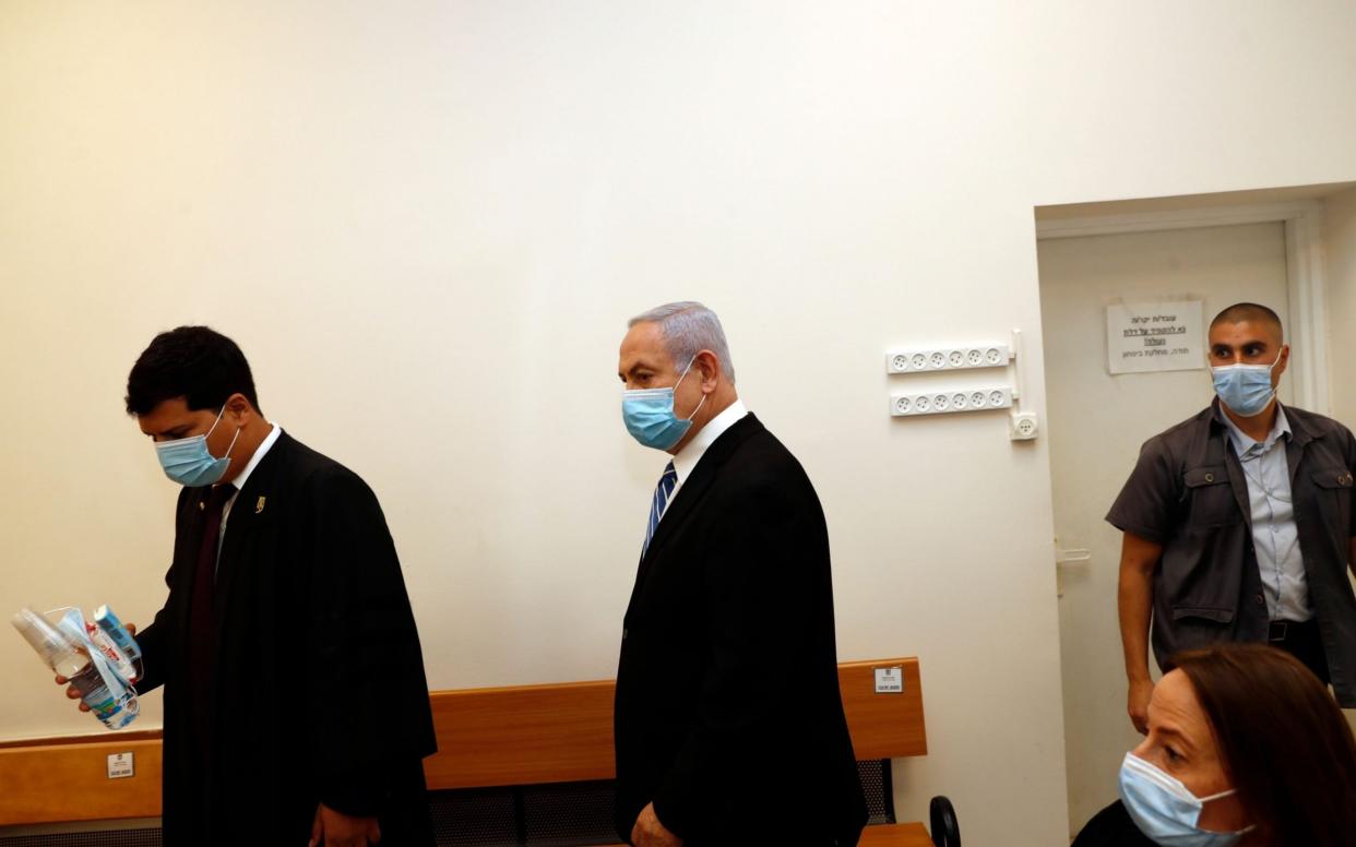 Israeli Prime Minister Benjamin Netanyahu (C) wearing a face mask, stands inside the court room on the first day of his trial for alleged corruption crimes - RONEN ZVULUN/POOL/EPA-EFE/Shutterstock/Shutterstock