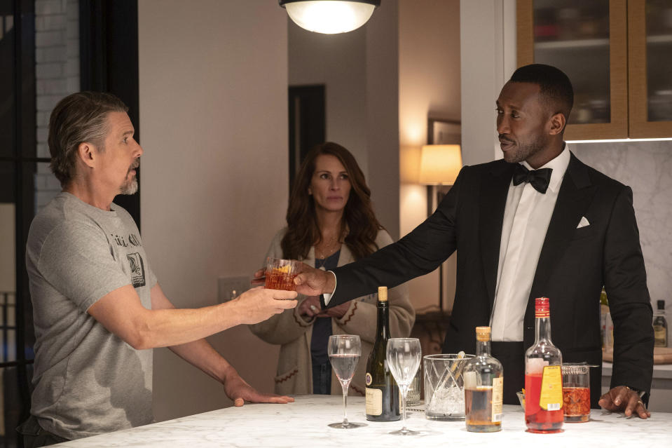 This image released by Netflix shows Ethan Hawke, from left, Julia Roberts and Mahershala Ali in a scene from "Leave the World Behind." (Netflix via AP)