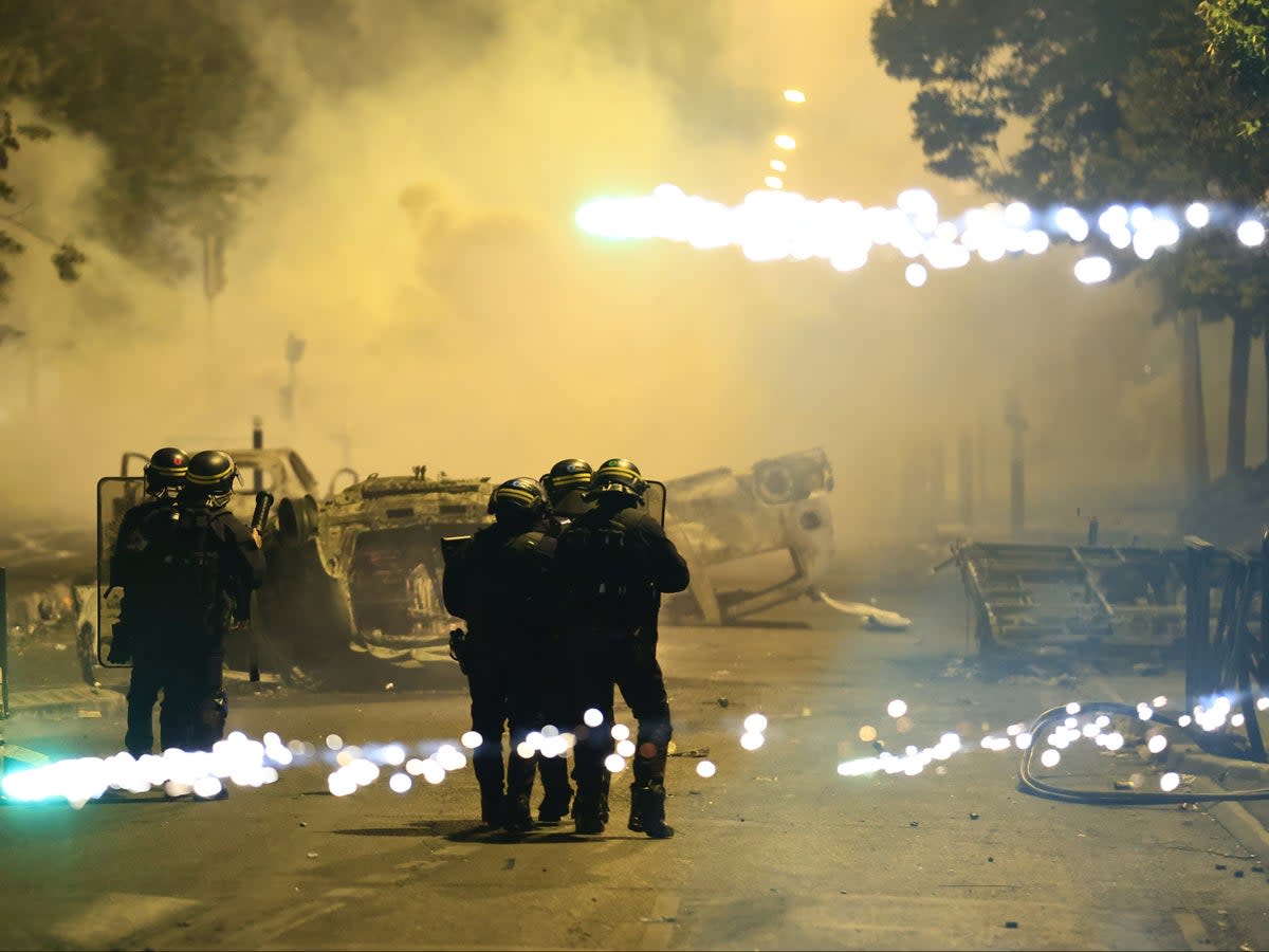 Fires were burning after cars were overturned in Nanterre (AP)