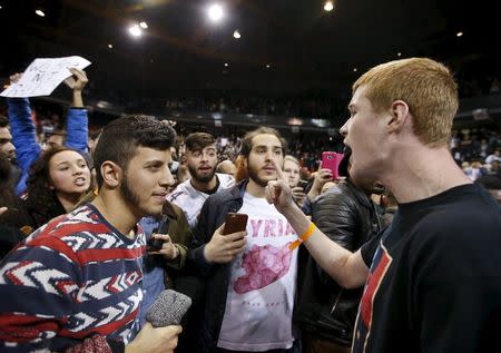 A Trump supporter (R) yells at demonstrators after Republican U.S. presidential candidate Donald Trump cancelled his rally at the University of Illinois at Chicago March 11, 2016. REUTERS/Kamil Krzaczynski