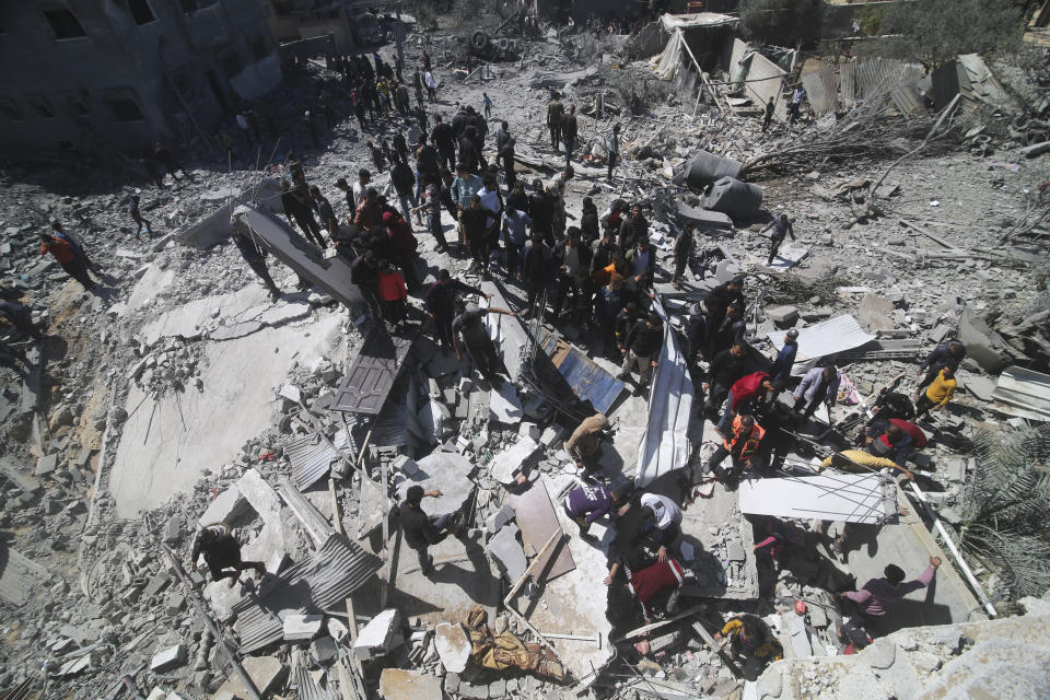 Palestinians look at a residential building destroyed in an Israeli strike in Rafah, Gaza Strip, Tuesday, March 20, 2024. (AP Photo/Hatem Ali)