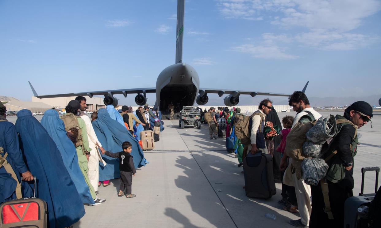 <span>US troops load passengers on board an air force plane on 24 August 2021 in Kabul, Afghanistan.</span><span>Photograph: US Air Forces Europe-Africa/Getty Images</span>