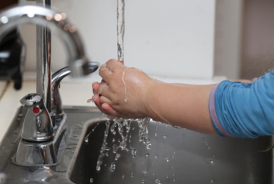 A child washes hands at a school sink in New Albany, Indiana.