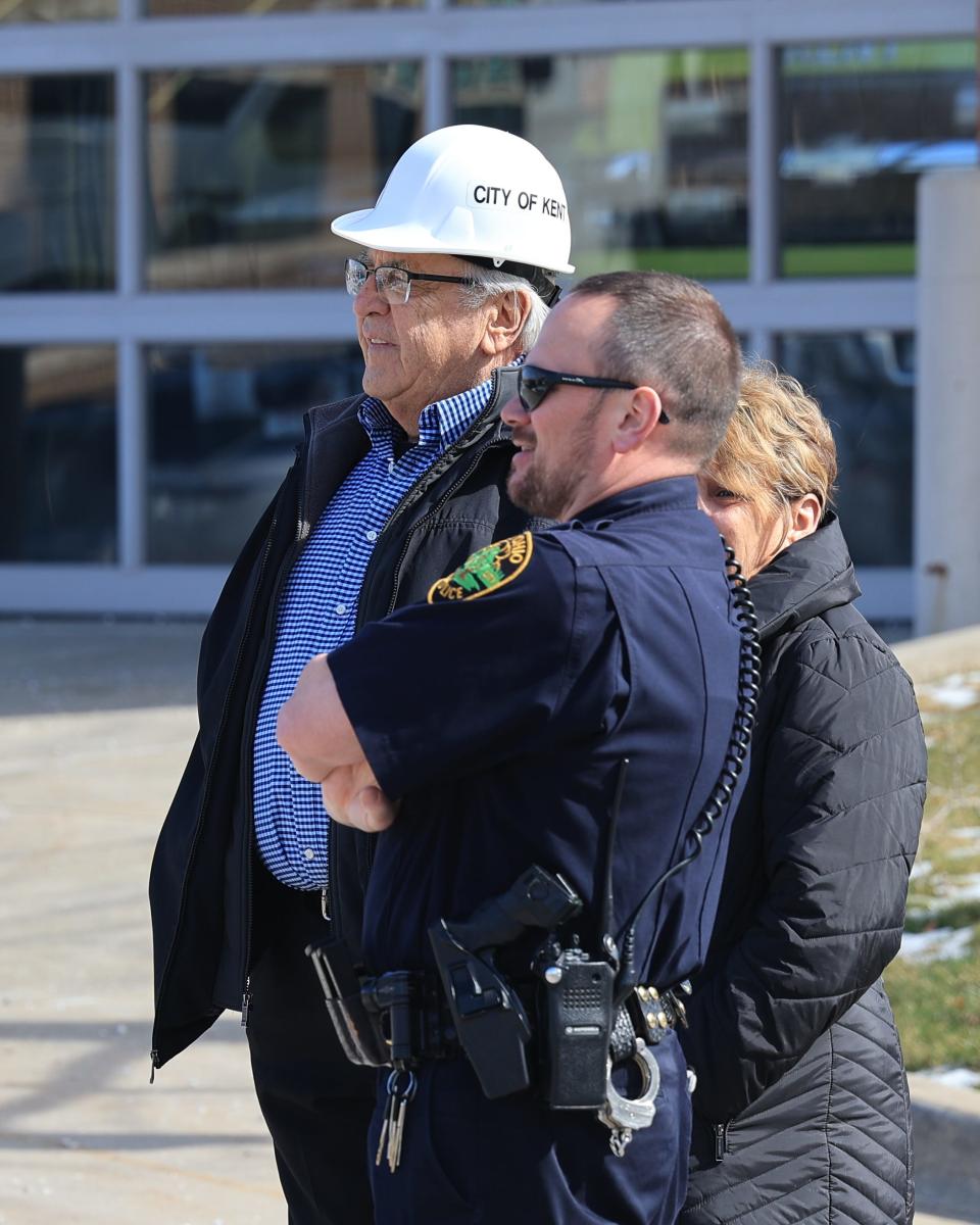 City of Kent Mayor Jerry Fiala, Police Chief Nick Shearer and others watch as demolition begins on the old City of Kent Police Department building located at the corner of Water Street and Haymaker Parkway Monday morning.