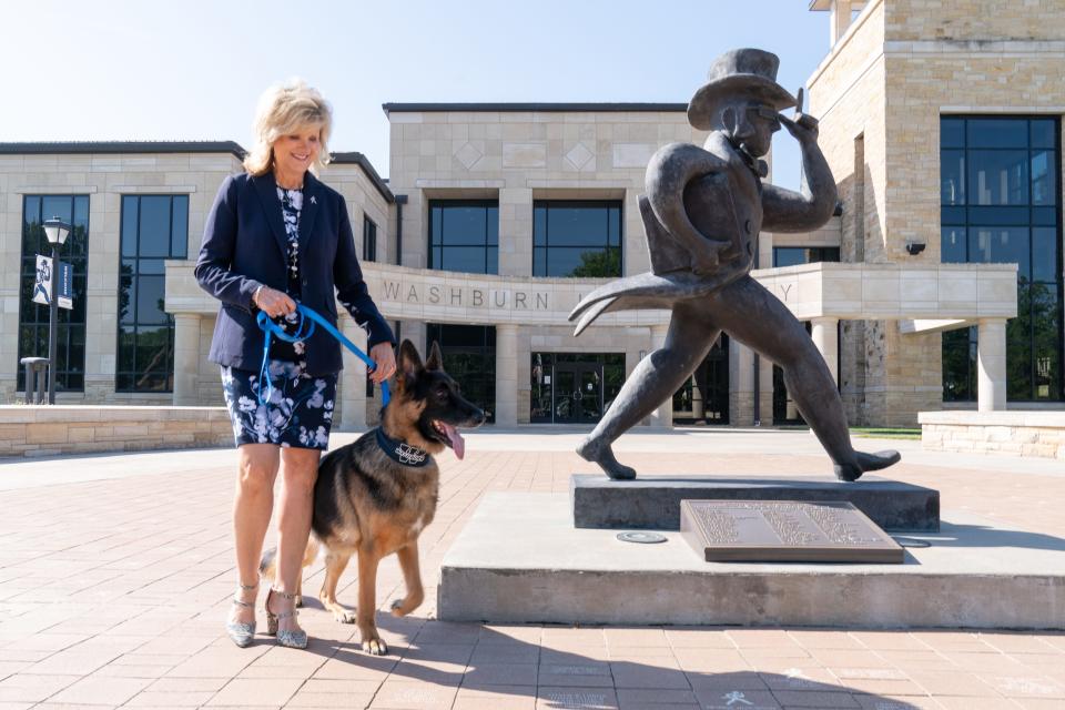 Washburn University president JuliAnn Mazachek walks her son's 7-year-old German shepherd, Harvey, outside of Morgan Hall on Thursday morning.