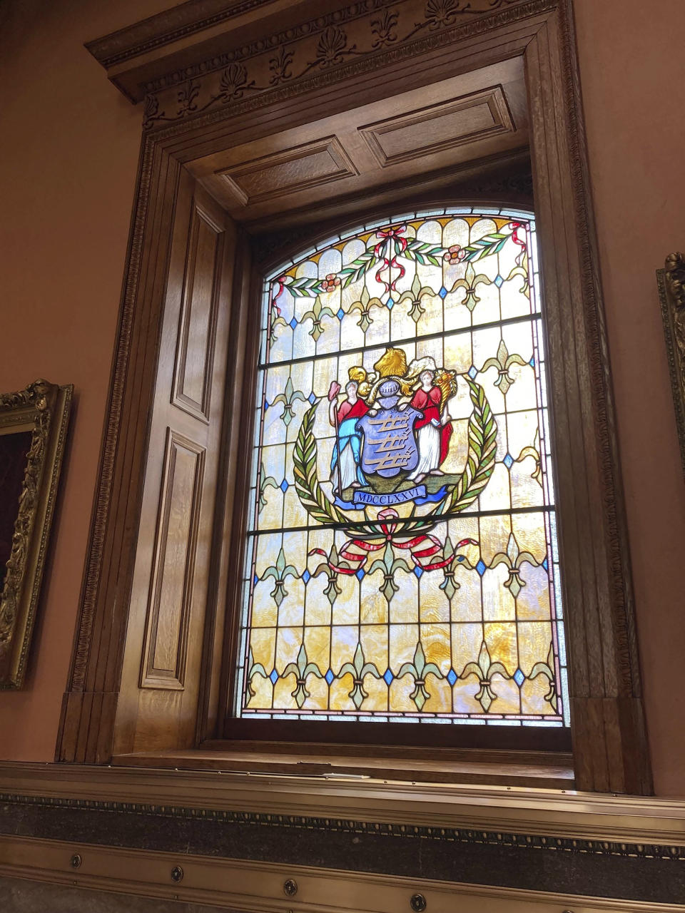 A stained-glass window illuminates the refurbished interior of New Jersey statehouse, Wednesday March 22, 2023, in Trenton, N.J. The building has been reopened and reoccupied by the governor's and other executive staff after a nearly six year, $300-million renovation. (AP Photo/Mike Catalini)