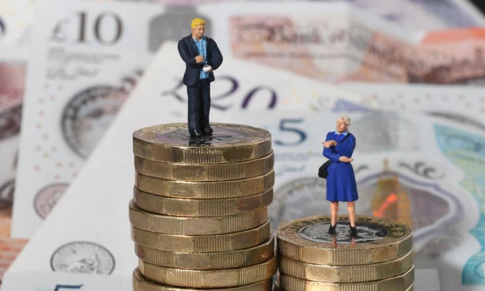 Models of a man and woman on a pile of coins and bank notes.