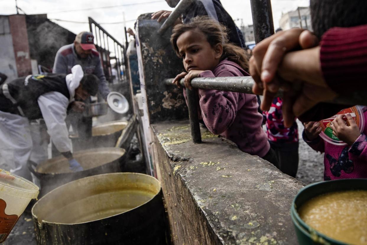 <span>Internally displaced people line up to receive food aid provided by a Palestinian youth group in the Rafah refugee camp, southern Gaza, on Thursday.</span><span>Photograph: Haitham Imad/EPA</span>