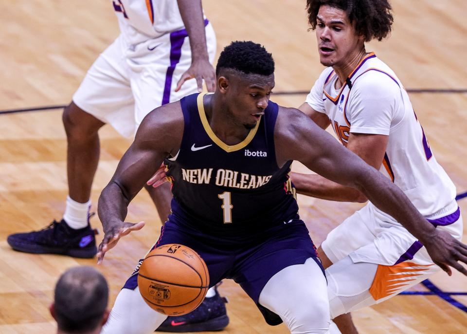 Feb 3, 2021; New Orleans, Louisiana, USA; New Orleans Pelicans forward Zion Williamson (1) drives to the basket around Phoenix Suns forward Cameron Johnson (23) during the first half at Smoothie King Center.