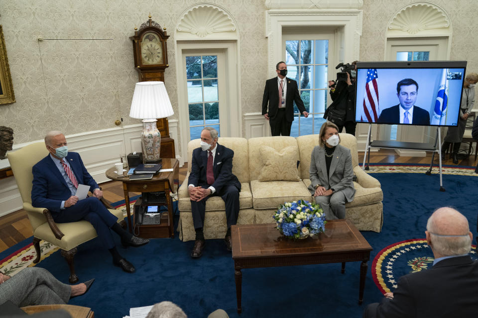 President Joe Biden speaks during a meeting with lawmakers on investments in infrastructure, in the Oval Office of the White House, Thursday, Feb. 11, 2021, in Washington. From left, Biden, Sen. Tom Carper, D-Del., Sen. Shelley Moore Capito, R-W.Va., and Transportation Secretary Pete Buttigieg, on screen. (AP Photo/Evan Vucci)