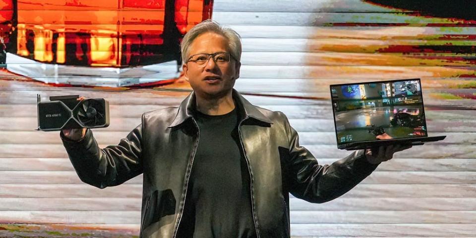 Nvidia president and CEO Jensen Huang holds a graphics card NVIDIA 4060Ti and a laptop at a keynote presentation at Computex, or the Taipei International Information Technology Show, on May 29, 2023.