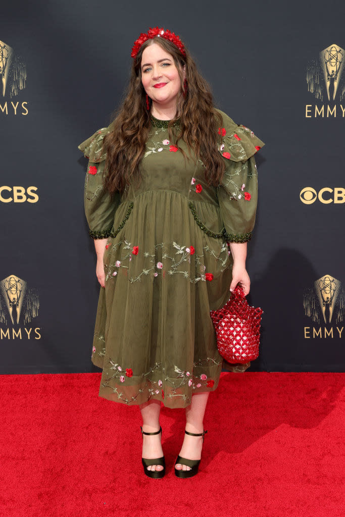Aidy wearing an ankle-length dress with floral embroidery and a head band