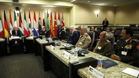 U.S. President Barack Obama speaks at a meeting with more than 20 foreign defense chiefs to discuss the coalition efforts in the ongoing campaign against ISIL at Joint Base Andrews in Washington October 14, 2014. REUTERS/Kevin Lamarque