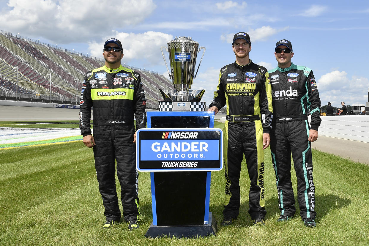 BROOKLYN, MICHIGAN - AUGUST 10: Matt Crafton, driver of the #88 Chi Chis/Menards Ford, Grant Enfinger, driver of the #98 ThorSport Racing/Curb Records Ford, and Johnny Sauter, driver of the #13 Tenda Heal Ford, pose with the playoff trophy after the NASCAR Gander Outdoor Truck Series Corrigan Oil 200 at Michigan International Speedway on August 10, 2019 in Brooklyn, Michigan. (Photo by Quinn Harris/Getty Images)