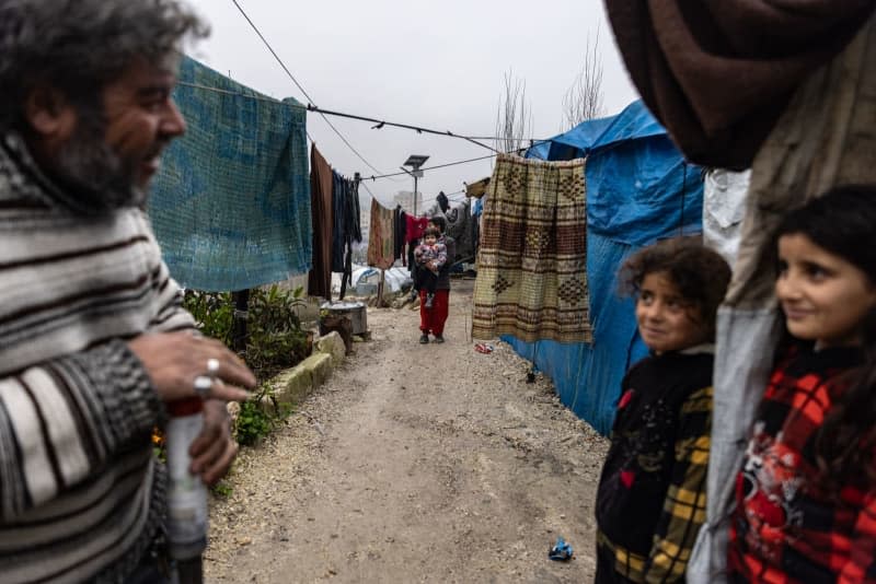 Displaced Syrians stand outside their damaged tents as a result of a rainstorm that struck the camps in northern Syria near the Syrian-Turkish border. Anas Alkharboutli/dpa