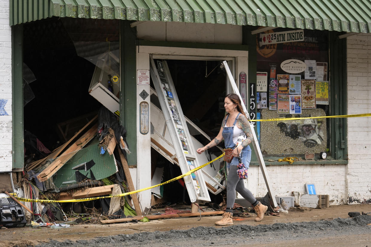 A person walks past a building heavily damaged during Hurricane Helene Tuesday, Oct. 1, 2024, in Hot Springs, N.C. (AP Photo/Jeff Roberson)