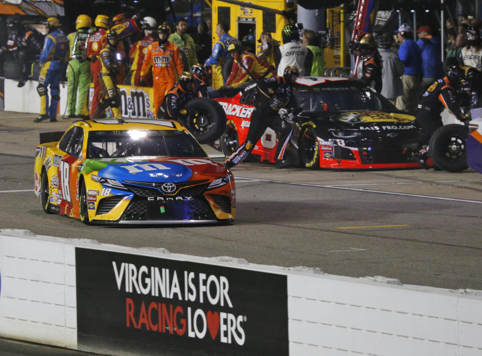 Kyle Busch (18) leaves his pit during the NASCAR Cup Series auto race at Richmond Raceway in Richmond, Va., Saturday, April 13, 2019. Busch was called for a speeding penalty on the stop. (AP Photo/Steve Helber)