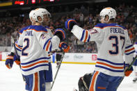 Edmonton Oilers defenseman Evan Bouchard (2) celebrates with left wing Warren Foegele after scoring a goal against the Arizona Coyotes in the first period during an NHL hockey game, Monday, March 27, 2023, in Tempe, Ariz. (AP Photo/Rick Scuteri)