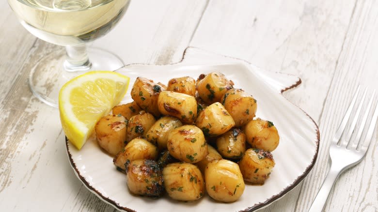 Bay scallops presented on scallop shell plate