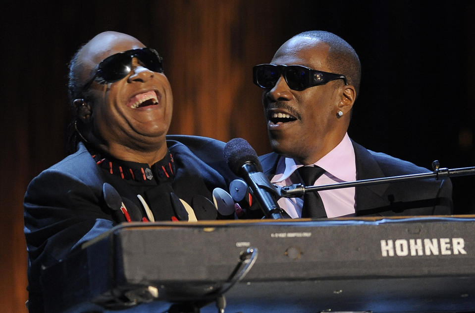 Stevie Wonder, left, is joined by Eddie Murphy to sing Wonder's song "Higher Ground" onstage during "Eddie Murphy: One Night Only," a celebration of Murphy's career at the Saban Theater on Saturday, Nov. 3, 2012, in Beverly Hills, Calif. (Photo by Chris Pizzello/Invision)