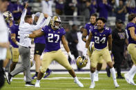 Washington players and coaches celebrate beating California in an NCAA college football game Saturday, Sept. 25, 2021, in Seattle. Washington won 31-24 in overtime. (AP Photo/Elaine Thompson)