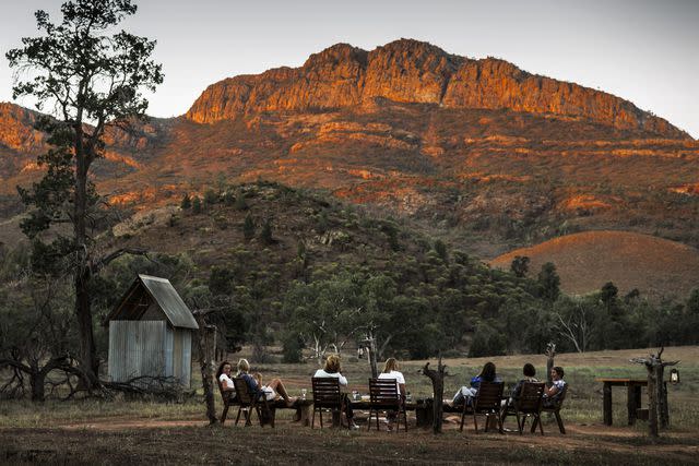 <p>Courtesy of Arkaba Conservancy</p> Sundowner drinks as the sun sinks behind Wilpena Pound at The Arkaba Conservancy