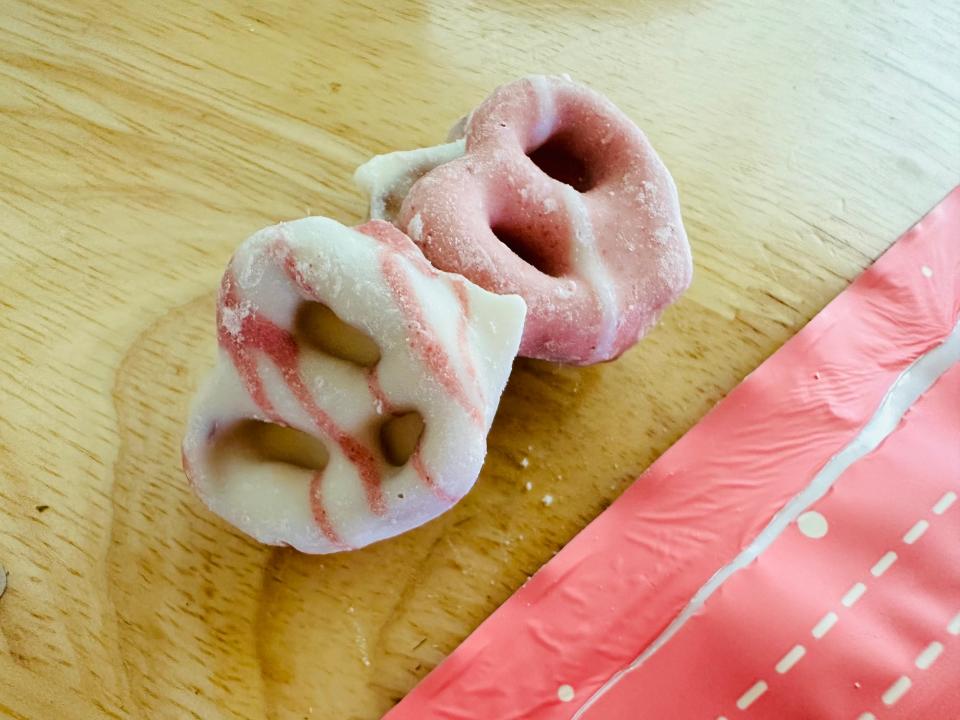 white and pink yogurt-covered pretzels sitting on wood table