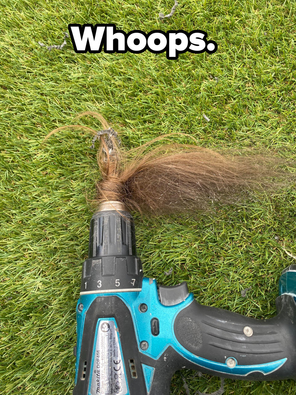 Hair tangled in a power drill lying on grass