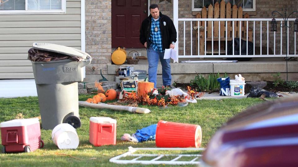 Pleasant Grove Police investigate the scene where seven infant bodies were discovered and packaged in separate containers at a home in Pleasant Grove, Utah, Sunday, April 13, 2014. According to the Pleasant Grove Police Department, seven dead infants were found in the former home of Megan Huntsman, 39. Huntsman was booked into jail on six counts of murder. (AP Photo/Rick Bowmer)