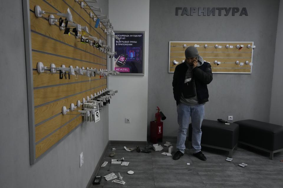 A man speaks on the phone inside a looted shop during unrest, in Almaty, Kazakhstan, Tuesday, Jan. 11, 2022. Nearly 8,000 people in Kazakhstan were detained by police during protests that descended into violence last week and marked the worst unrest the former Soviet nation has faced since gaining independence 30 years ago, authorities said Monday. (AP Photo)