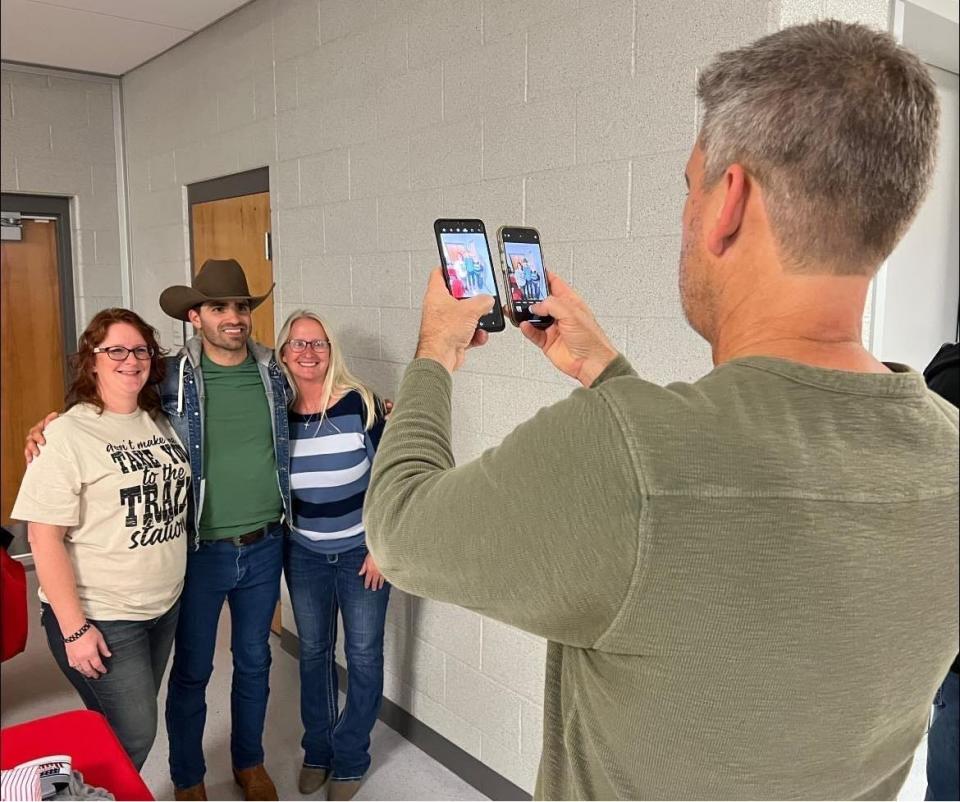 Country music singer-songwriter Mitch Rossell poses with fans for a photo following his November concert at Canton South High School. Rossell debuted in December at the Grand Ole Opry, where he was introduced by country music icon Garth Brooks.