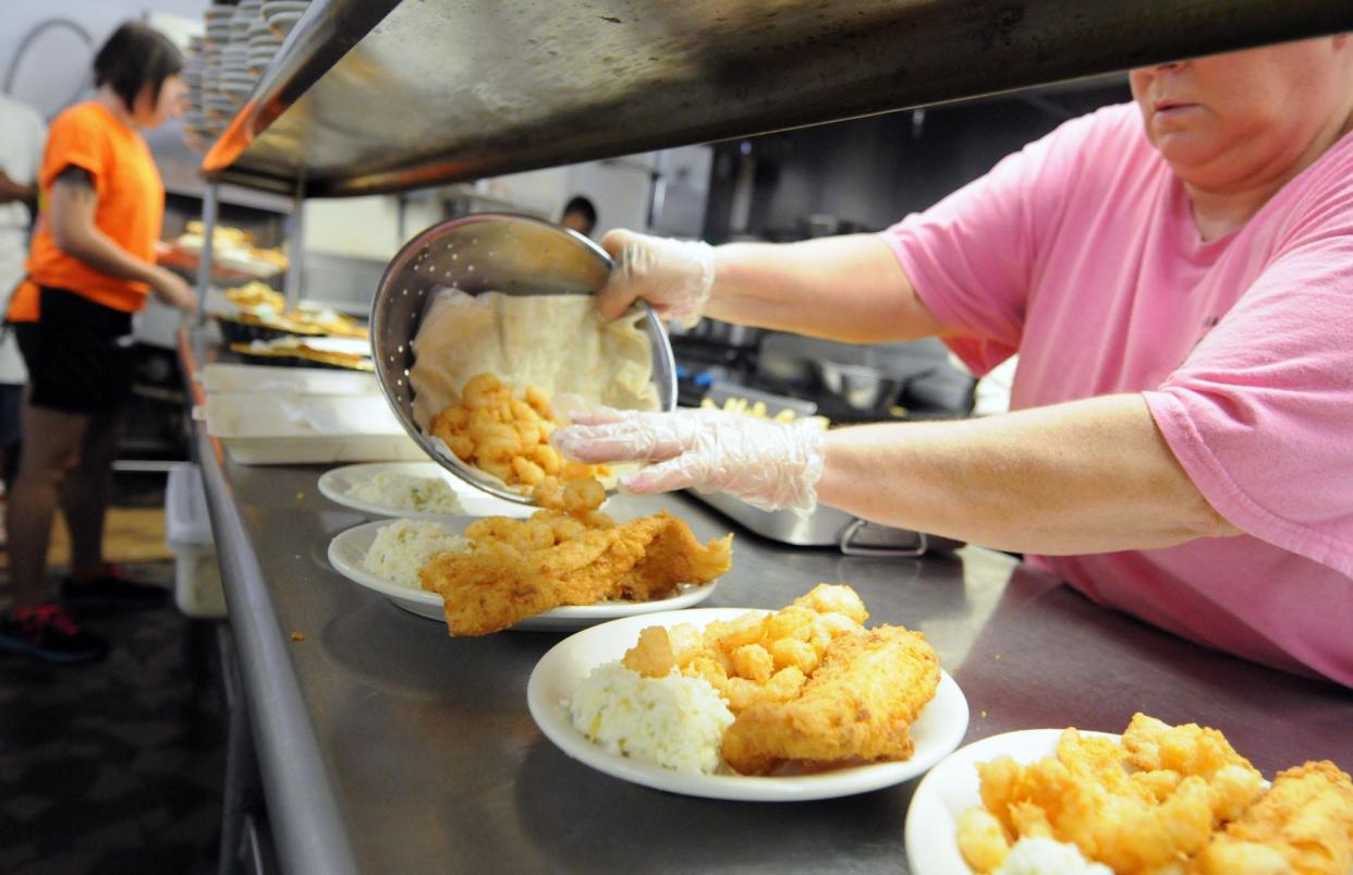 Sherri Owens places fried shrimp onto plates in the kitchen at the Calabash Seafood Hut in Calabash, North Carolina Wednesday, September 17, 2014.