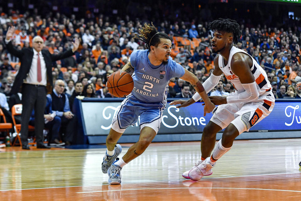 North Carolina guard Cole Anthony, left, is defended by Syracuse forward Quincy Guerrier during the second half of an NCAA college basketball game in Syracuse, N.Y., Saturday, Feb. 29, 2020. North Carolina defeated Syracuse 92-79. (AP Photo/Adrian Kraus)