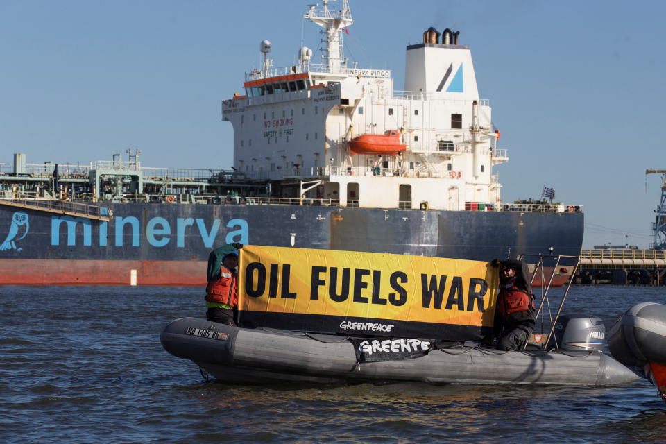 Activists from Greenpeace hold a banner near the oil tanker Minerva Virgo, docked at the oil terminal, after leaving a Russian port around the time that nation invaded Ukraine in late February, as U.S. President Joe Biden on March 8 banned the importation of Russian energy, giving buyers until late April to wind down purchases, when several tankers linked to Russian oil are still in and around U.S. waters, according to Refinitiv data, at Bayonne New Jersey, U.S., March 22, 2022.  REUTERS/Bjoern Kils