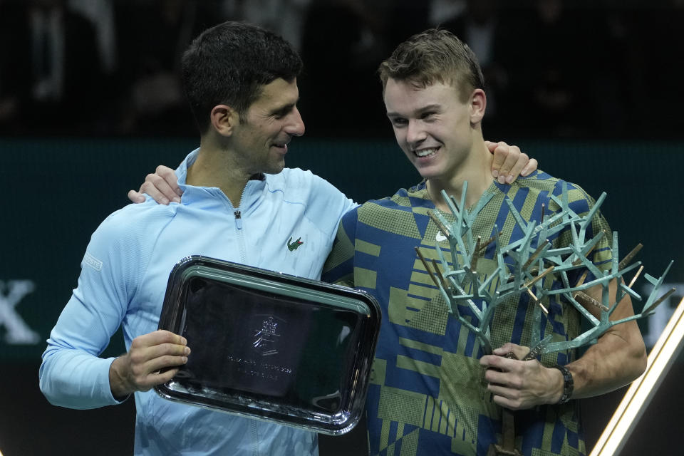 Holger Rune (derecha) y Novak Djokovic posan con sus trofeos tras la final del Masters de París, el domingo 6 de noviembre de 2022. Rune ganó en tres sets. (AP Foto/Thibault Camus)