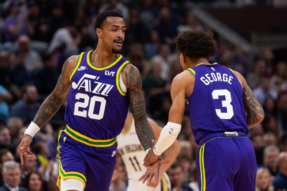 Utah Jazz forward John Collins (20) high-fives teammate Keyonte George (3)