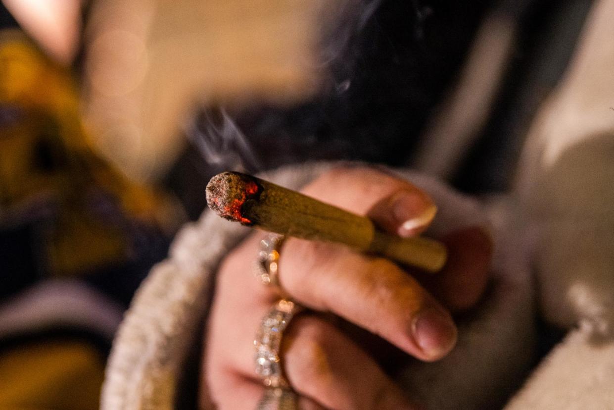 <span>A customer smokes while waiting in line outside the Housing Works Cannabis Co on the first day of legal recreational cannabis sales in New York on 29 December 2022.</span><span>Photograph: Jeenah Moon/Bloomberg via Getty Images</span>