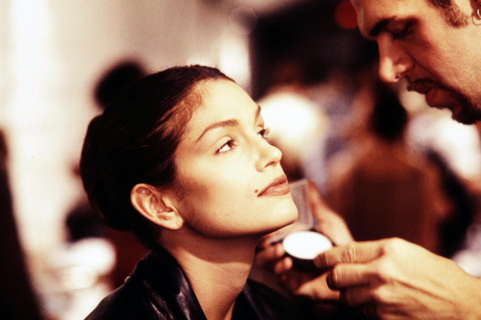 Makeup artist Kevyn Aucoin applies makeup on model Cindy Crawford