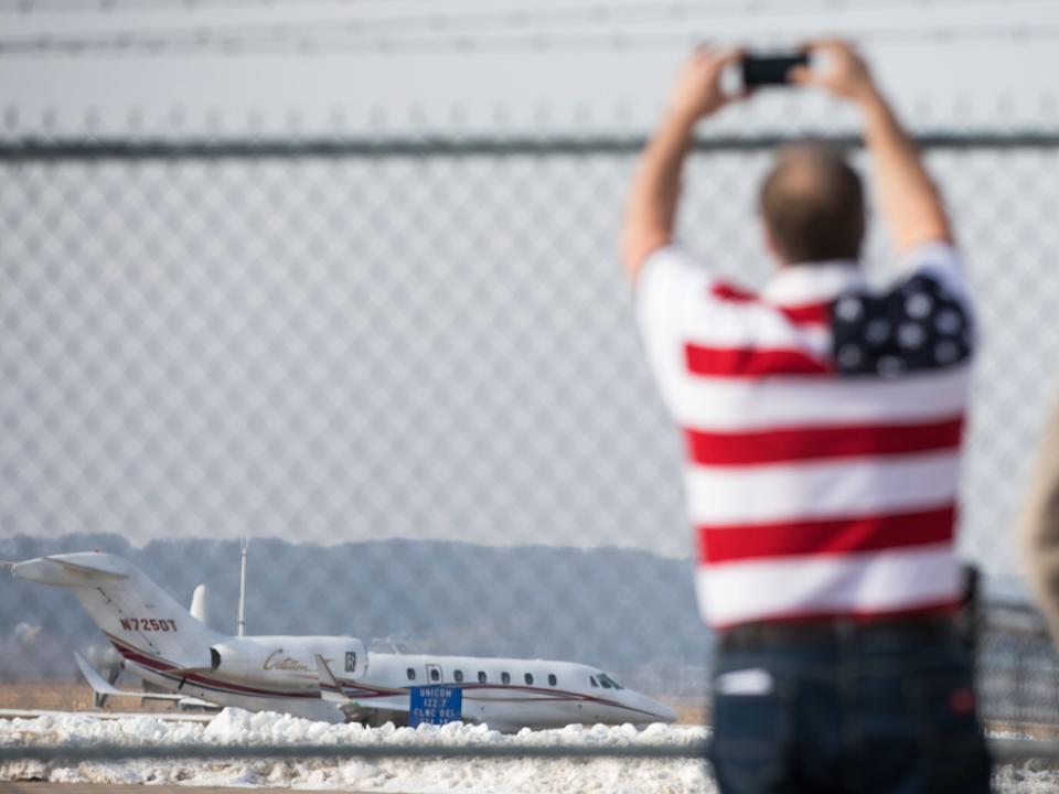 A man photographs the plane carrying Republican presidential candidate Donald Trump as it departs Muscatine Municipal Airport