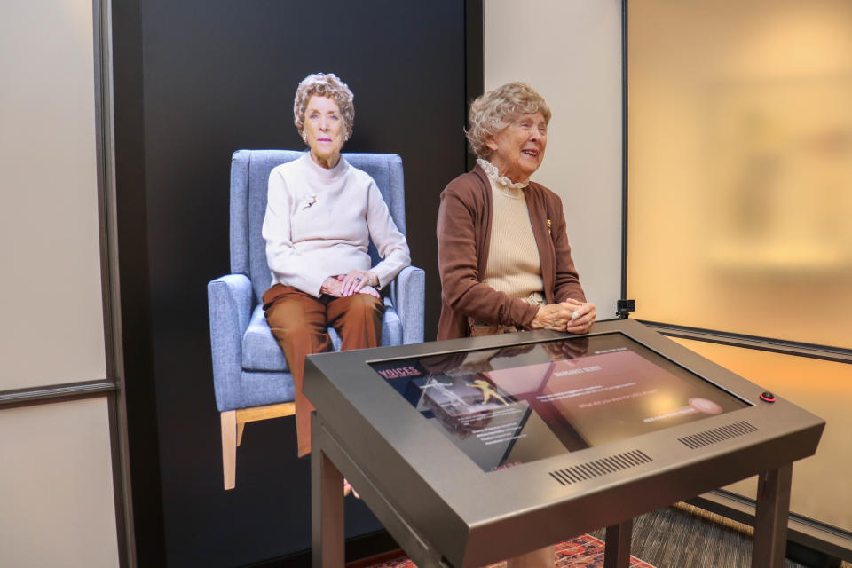 Former USO dancer Margaret Kerry-Boeke, who sat for two days of interviewers and answered nearly 1,000 questions on camera, stands with her video image at the Voices From the Front exhibit at the National WWII Museum in New Orleans. (La'Shance Perry)