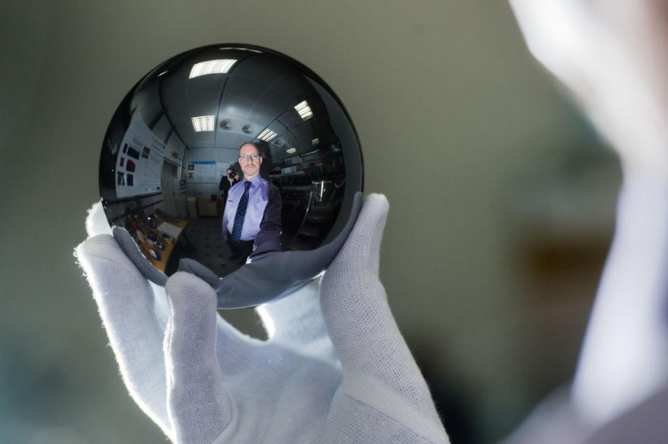 A hand holding a reflective sphere