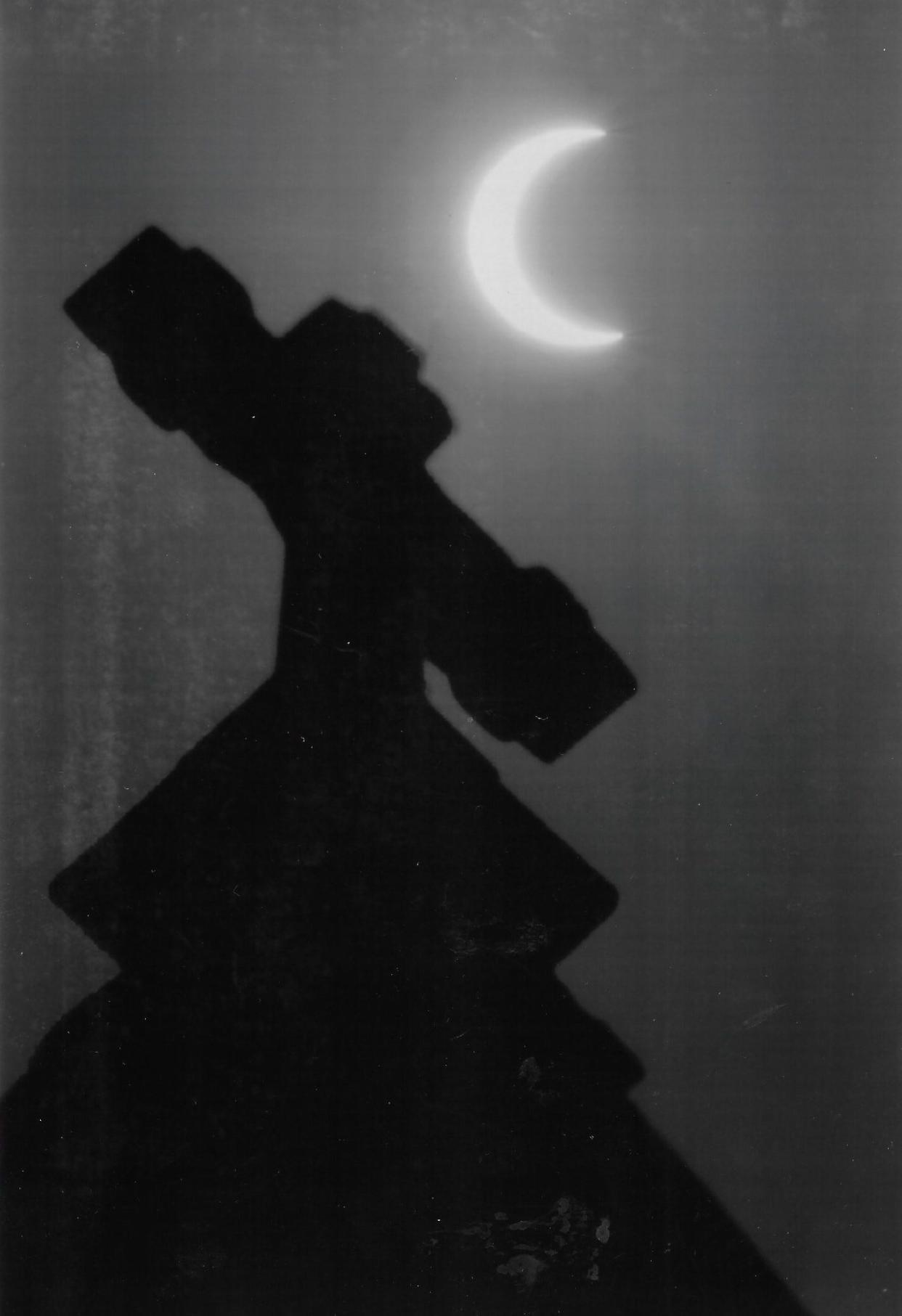 A crescent sun shines behind the steeple of St. Bernard Catholic Church in downtown Akron during an annular eclipse May 10, 1994.