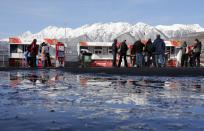 People stand near food stalls on a sunny day at the Sanki Sliding Center in Rosa Khutor, a venue for the Sochi 2014 Winter Olympics near Sochi, February 12, 2014. REUTERS/Fabrizio Bensch