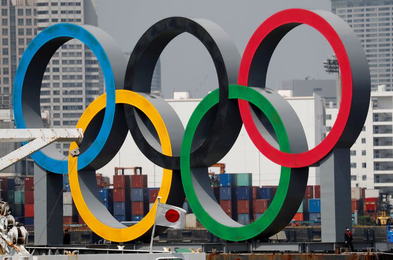 FILE PHOTO: FILE PHOTO: The giant Olympic rings, which are being temporarily removed for maintenance, are seen behind Japan's national flag, at the waterfront area at Odaiba Marine Park in Tokyo