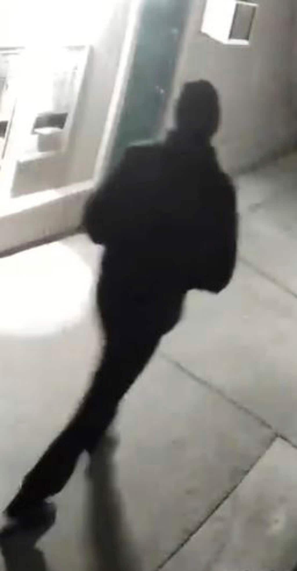 In this undated surveillance image released by the Stockton Police Department, a grainy still image of a “person of interest,” dressed all in black and wearing a black cap, who appeared in videos from several of the homicide crime scenes in Stockton. Ballistics tests have linked the fatal shootings of six men and the wounding of one woman in California— all potentially at the hands of a serial killer — in crimes going back more than a year, police said Monday. (Stockton Police Department via AP)