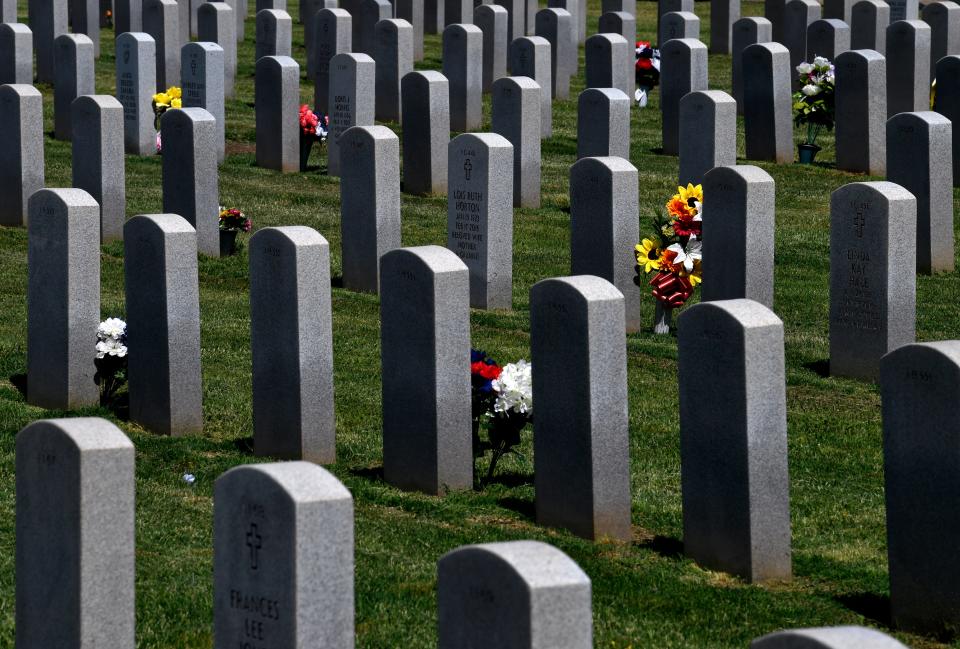 Flower displays sit beside gravestones at the Texas State Veterans Cemetery at Abilene in 2020.