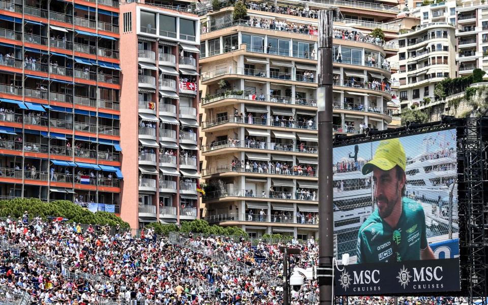 Spectators watch from balconies and the stands as Aston Martin's Spanish driver Fernando Alonso is displayed on a screen during the drivers' parade ahead of the Formula One Monaco Grand Prix at the Monaco street circuit in Monaco, on May 28, 2023 - Olivier Chassignole/Getty Images