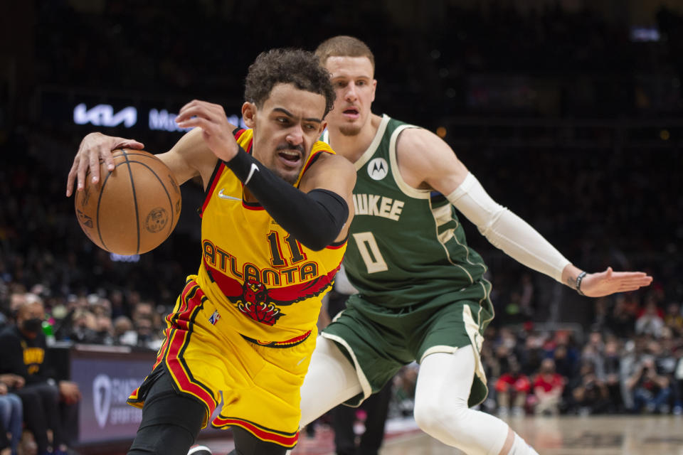 Atlanta Hawks guard Trae Young (11) dribbles past Milwaukee Bucks guard Donte DiVincenzo (0) during the second half of an NBA basketball game Monday, Jan. 17, 2022, in Atlanta. (AP Photo/Hakim Wright Sr.)